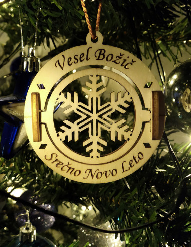 Custom text christmas ornament featuring a rotating snowflake design