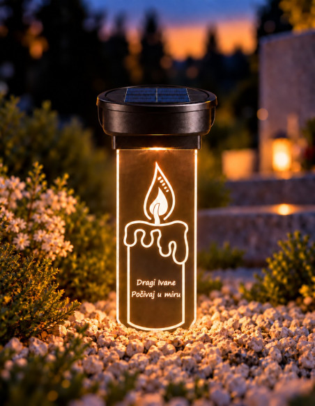 Personalized solar grave candle with engraved flame glowing warmly beside flowers at dusk