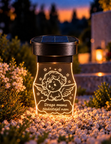Solar-Grablicht mit graviertem Engel und persönlicher Widmung, neben Blumen in der Dämmerung beleuchtet
