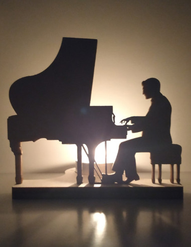 Candlelit silhouette of pianist at piano casting soft shadows