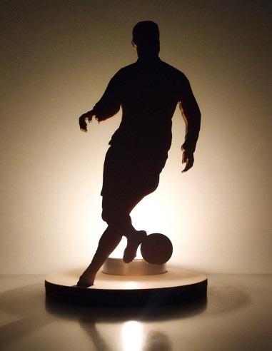 decorazione con luce e silhouette calciatore in movimento