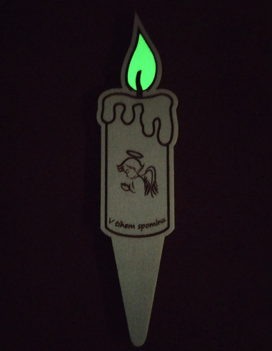 Wooden grave candle with luminous flame glowing softly in the dark