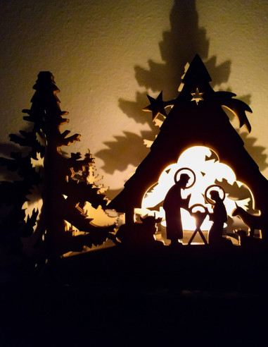 Holz-Krippenszene mit Teelicht – leuchtende Silhouette von Maria, Josef und dem Kind