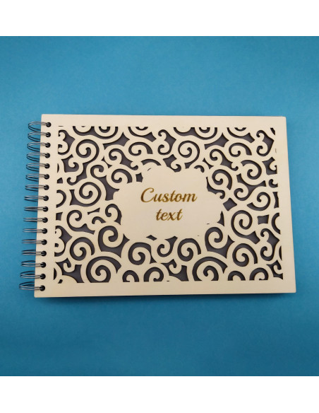 Close-up of personalized photo album with cloud pattern design and engraved text